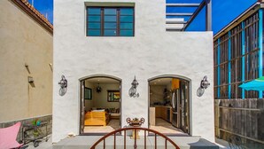 A modern building with a white facade, two arched entrances, and a small window. - Casa al Mare - Boho Mission Beach Retreat w/ A/C (San Diego)