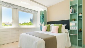 Un dormitorio moderno con una cama grande, vistas a la ciudad y una estantería verde.
