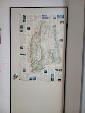 Mapa colgado en la pared con diversos lugares señalados y descripciones de texto.