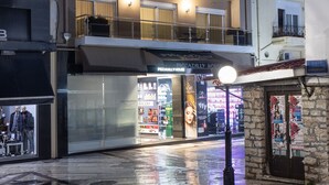 Un hotel de varios pisos con balcones y un espacio comercial en la planta baja.