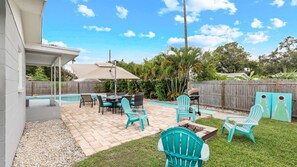 Un jardin avec une piscine, du mobilier de jardin et une clôture en bois.