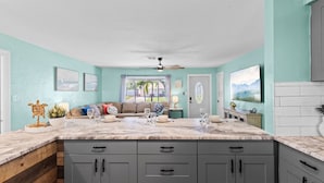 A kitchen with a marble countertop, grey cabinets, and a view of the outdoors. - Family Fun Getaway w/Pool, Game Room, Shuffleboard (Largo)
