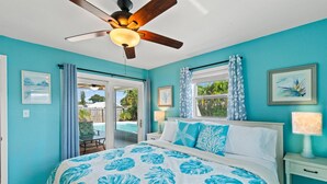 A bedroom with a bed, a ceiling fan, a window with curtains, and a view of the outdoors. - Family Fun Getaway w/Pool, Game Room, Shuffleboard (Largo)