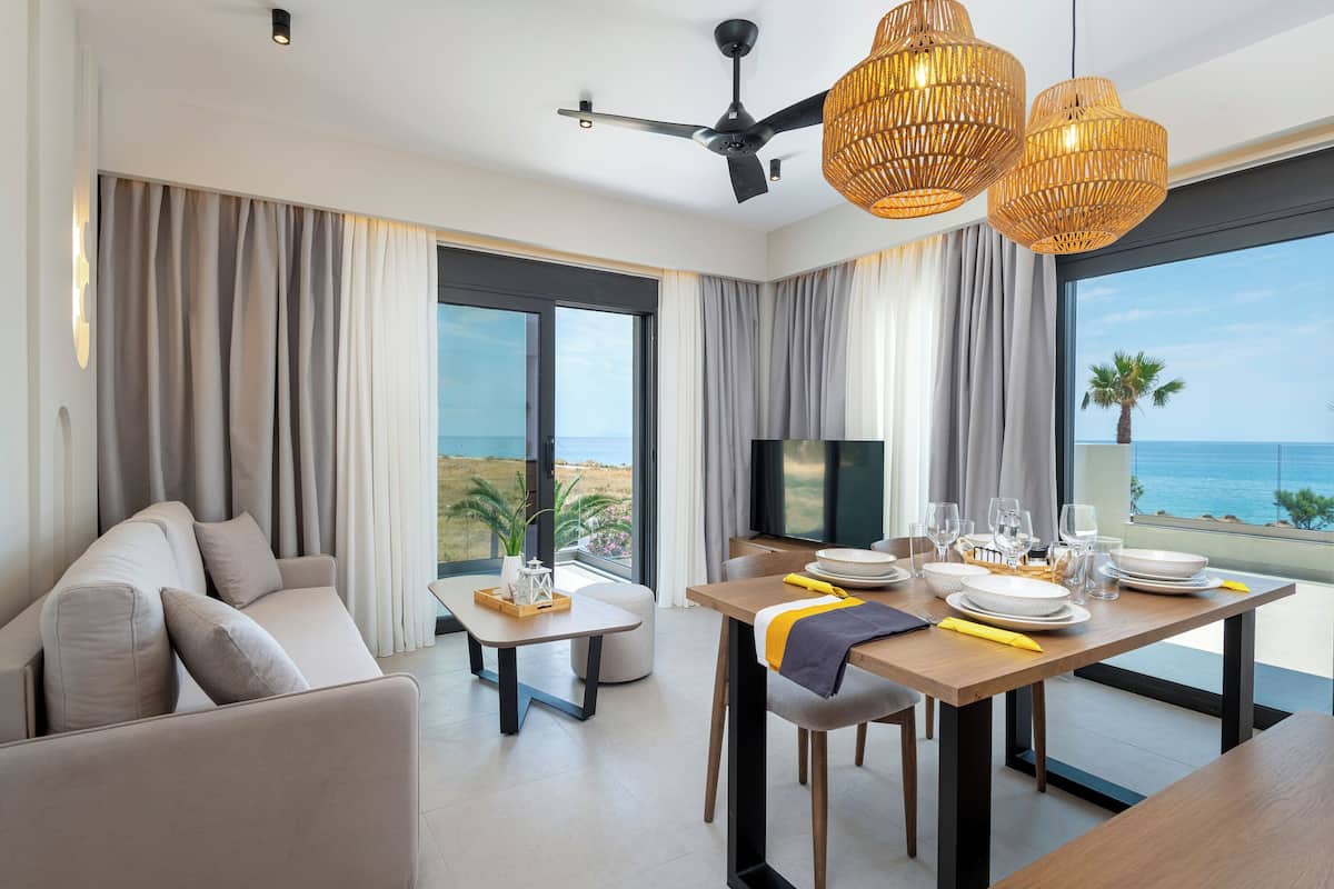 Ein modernes Hotelzimmer mit großem Balkon, einem Essbereich und einer Sitzecke.
