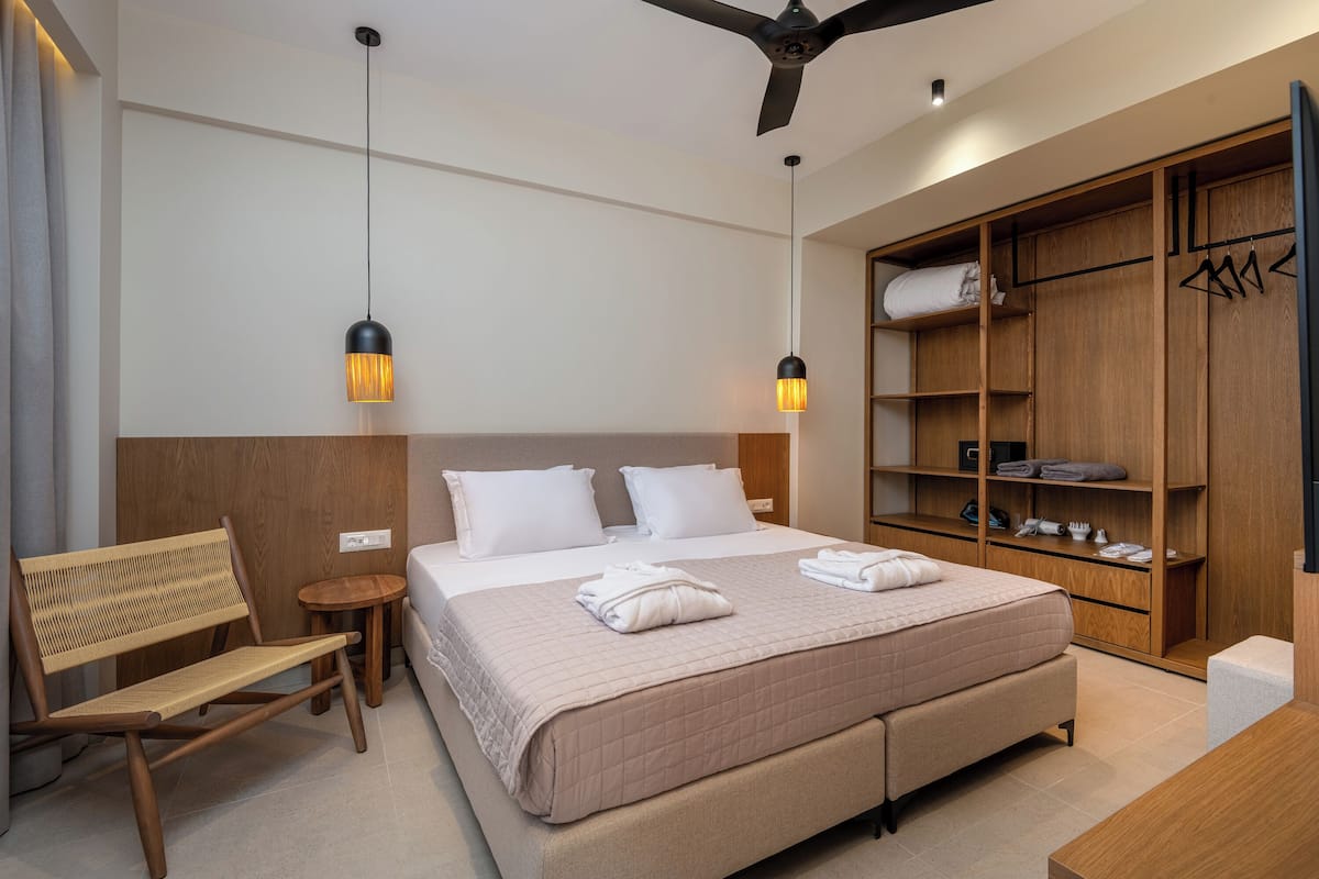 Ein Schlafzimmer mit einem Bett, Nachttischen, einem Holzschrank und einem Deckenventilator.