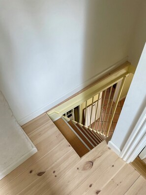 A wooden staircase with a handrail and a landing area.