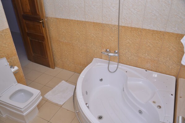 A bathroom with a toilet, a bathtub, and a shower.