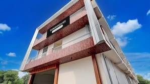 A multi-story building with a sign indicating it is a townhouse and company-serviced.