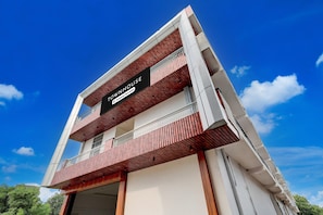 Un immeuble à plusieurs étages, sur lequel on peut lire une enseigne indiquant qu’il s’agit d’une maison de ville et qu’il propose des services aux entreprises.