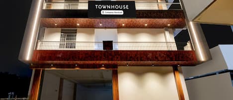 A multi-story building with a sign reading 'TOWNHOUSE Company-Serviced'.