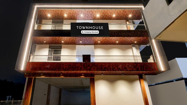 A multi-story building with a sign reading 'TOWNHOUSE Company-Serviced'.