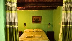Une chambre avec un lit, deux tables de chevet, un luminaire fixé au mur et un tableau encadré.