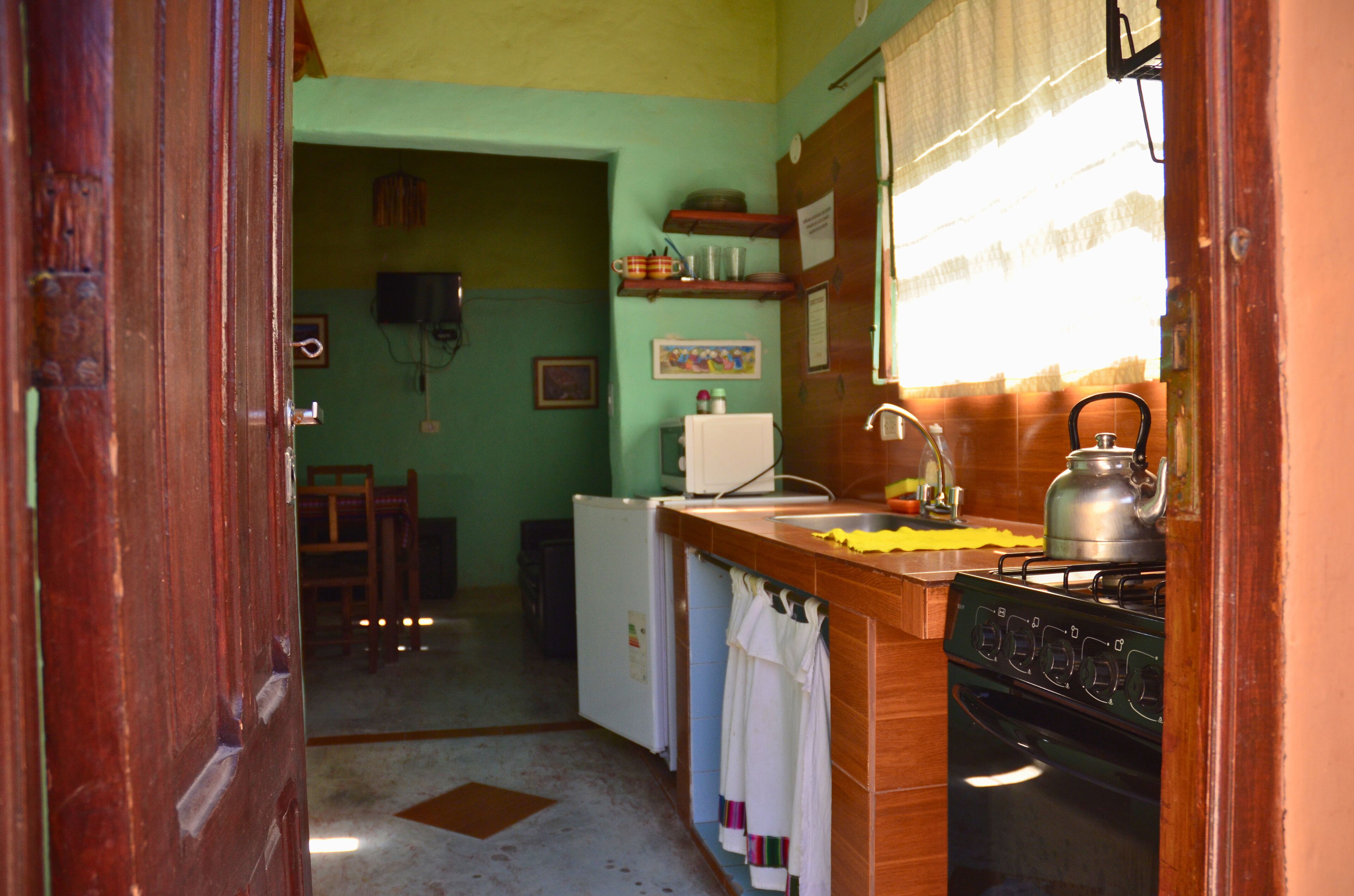 A kitchen with a wooden counter, a stove, a refrigerator, and a sink.
