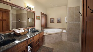 Une salle de bain avec un grand miroir, un lavabo, une baignoire et une douche.