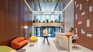 A modern lobby with a reception desk, seating areas, and a glass entrance. - Next White Aparthotel Official (Batumi)