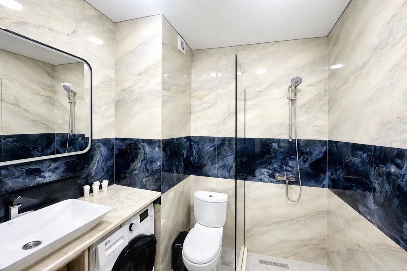 A bathroom with a sink, toilet, and shower.