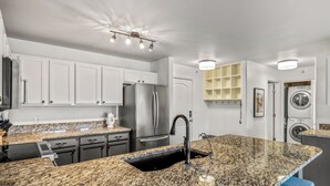 A modern kitchen with granite countertops, stainless steel appliances, and a built-in sink. - Bright, Beautiful First Tracks Condo W/ Pool & Spa 1084 (Steamboat Springs)