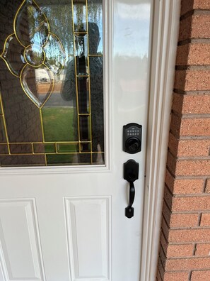 A white door with a glass panel featuring a geometric design. - Refurnished and spacious 4 bedroom house, Sleeps 8! (Blanding)