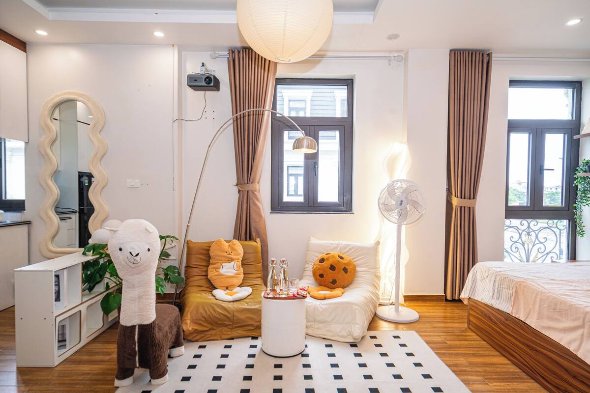 Een moderne hotelkamer met een groot bed, een bank, een eettafel en een spiegel.