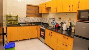 Una cocina moderna con armarios de madera, estufa, microondas y refrigerador.