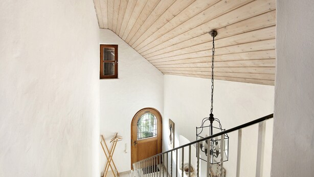 A staircase with a wooden railing, a wooden door, and a hanging light fixture. - Holiday Home 'Landhaus in Pförring' with Balcony and Wi-Fi (Pförring)