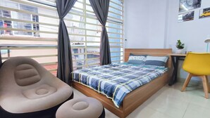 A bedroom with a bed, a chair, a small table, and a potted plant. - FSHOME (Ho Chi Minh City)