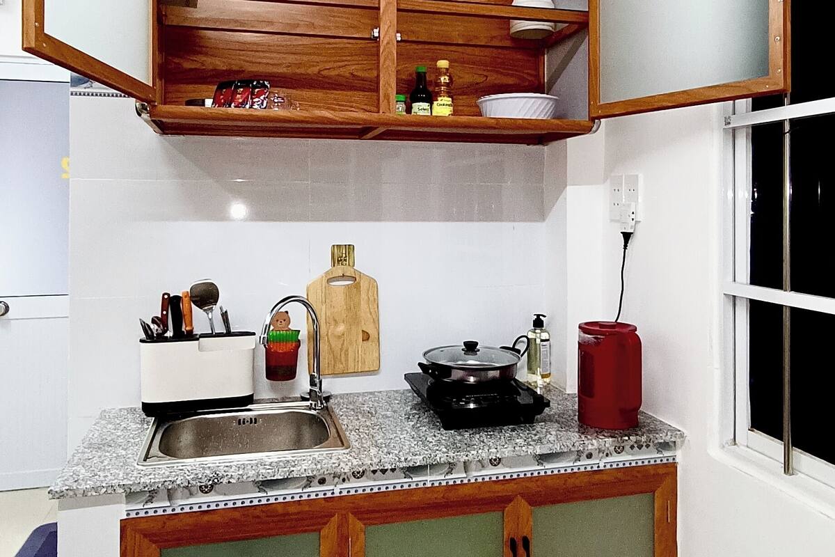 A kitchen with wooden cabinets, a granite countertop, and a window.