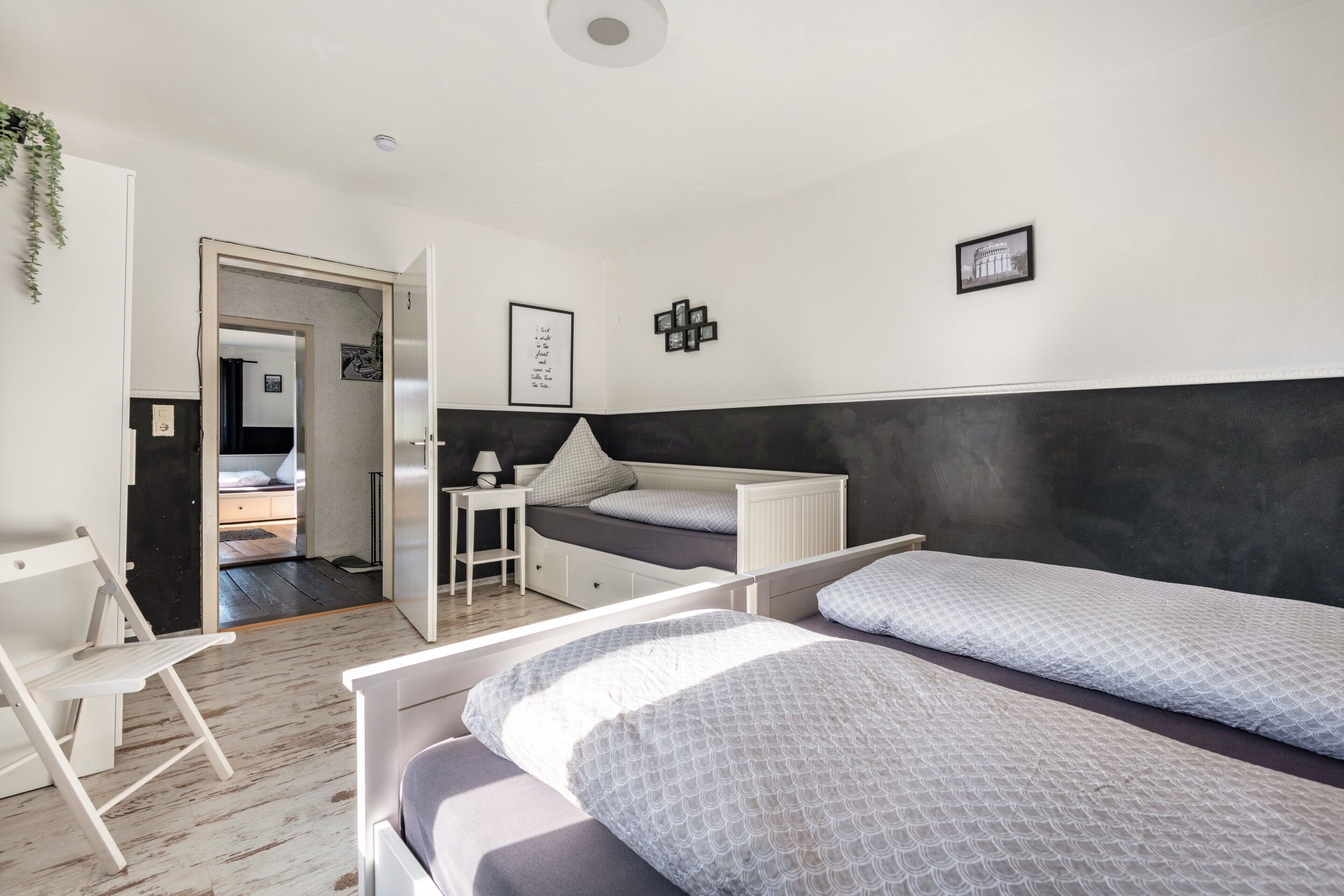 Ein modernes Schlafzimmer mit Bett, Nachttisch und Schreibtisch mit Stuhl.