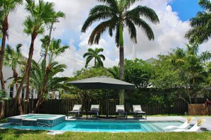 Una piscina al aire libre, sombrillas, tumbonas