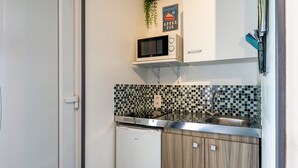 A compact kitchen with a microwave, sink, and a small refrigerator. - Studio 'Luberon' with Mountain View, Wi-Fi and Air Conditioning (Taillades)