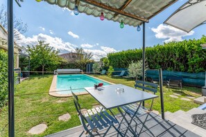 A backyard with a swimming pool, a table, and chairs. - Studio 'Luberon' with Mountain View, Wi-Fi and Air Conditioning (Taillades)