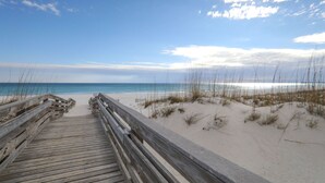 A wooden boardwalk leading to a sandy beach with dunes. - Baywatch F-3 (Pensacola Beach)