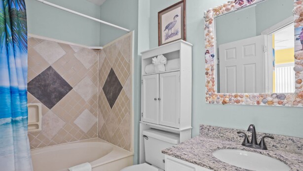 A bathroom with a bathtub, toilet, and sink. - Baywatch F-3 (Pensacola Beach)