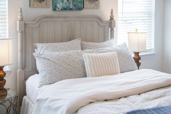 A bed with a wooden headboard, white bedding, and two bedside lamps. - Family-Friendly 3BR Condo Sleeps 9, Ensuite Bathrooms (Oxford)