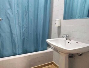 A bathroom with a bathtub, a sink, and a blue shower curtain. - Rotunda 2 & 3 (Lordelo do Ouro e Massarelos)