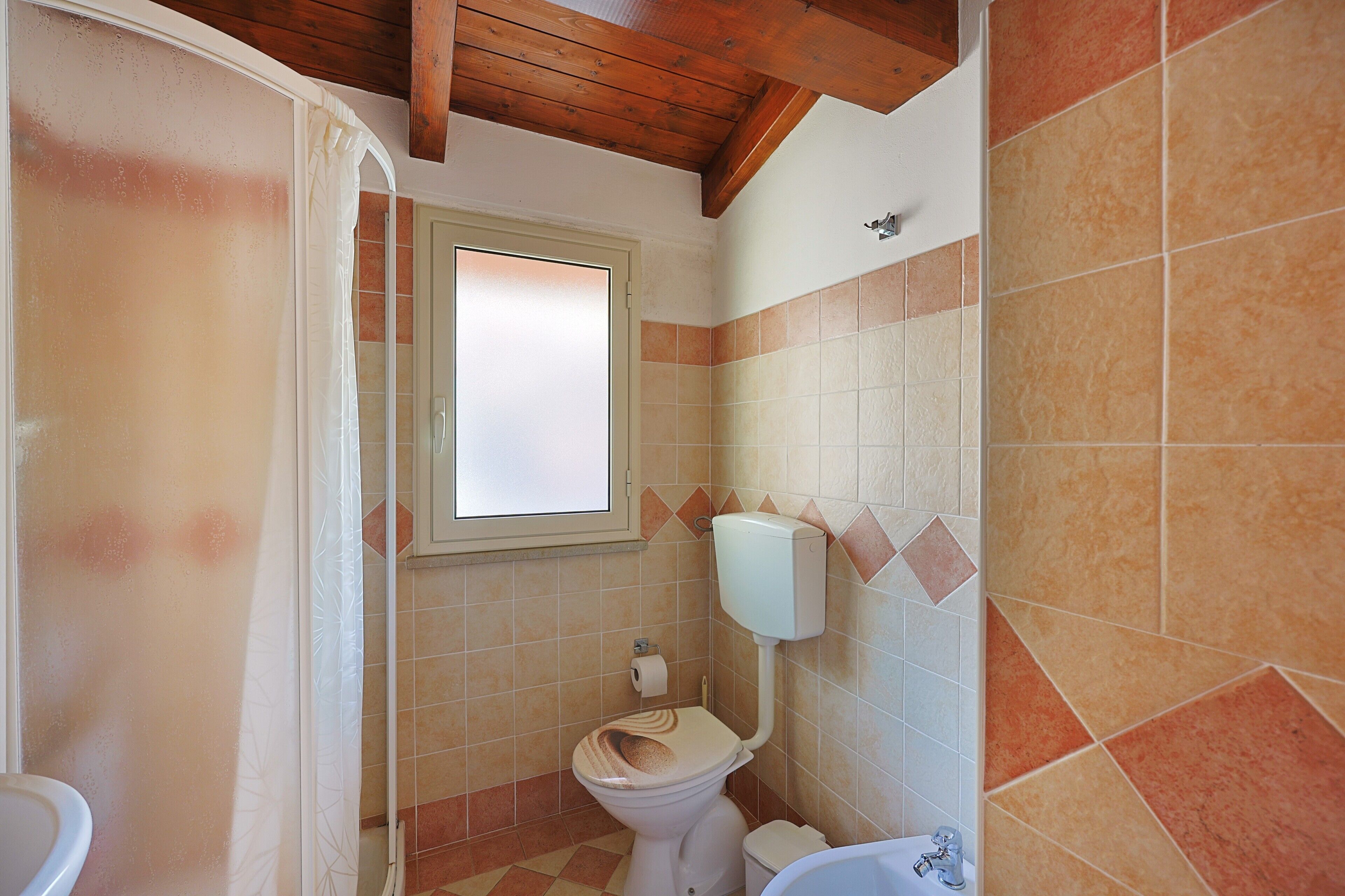 A bathroom with a toilet, a shower, and a bathtub.