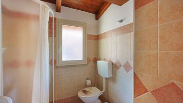 A bathroom with a toilet, a shower, and a bathtub.