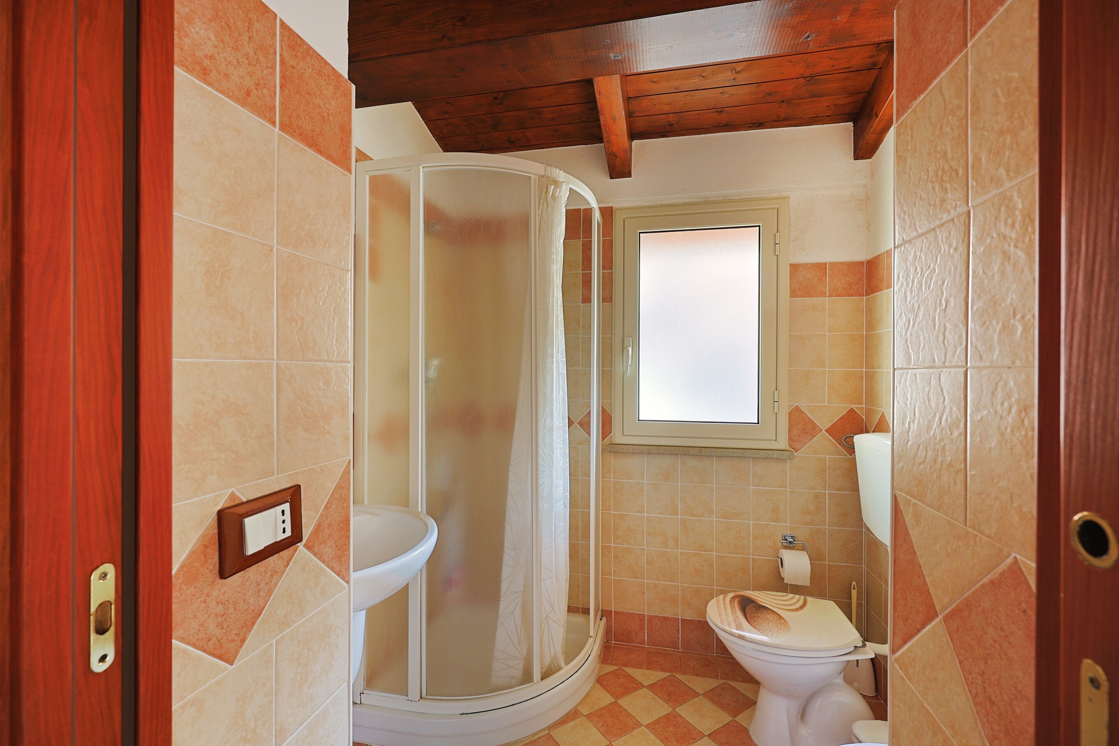 Une salle de bain avec douche, toilettes et lavabo.