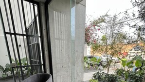 Un intérieur moderne avec une porte vitrée donnant sur un espace jardin extérieur.