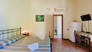 Ein Schlafzimmer mit Bett, Nachttisch, Lampe und Klimaanlage.