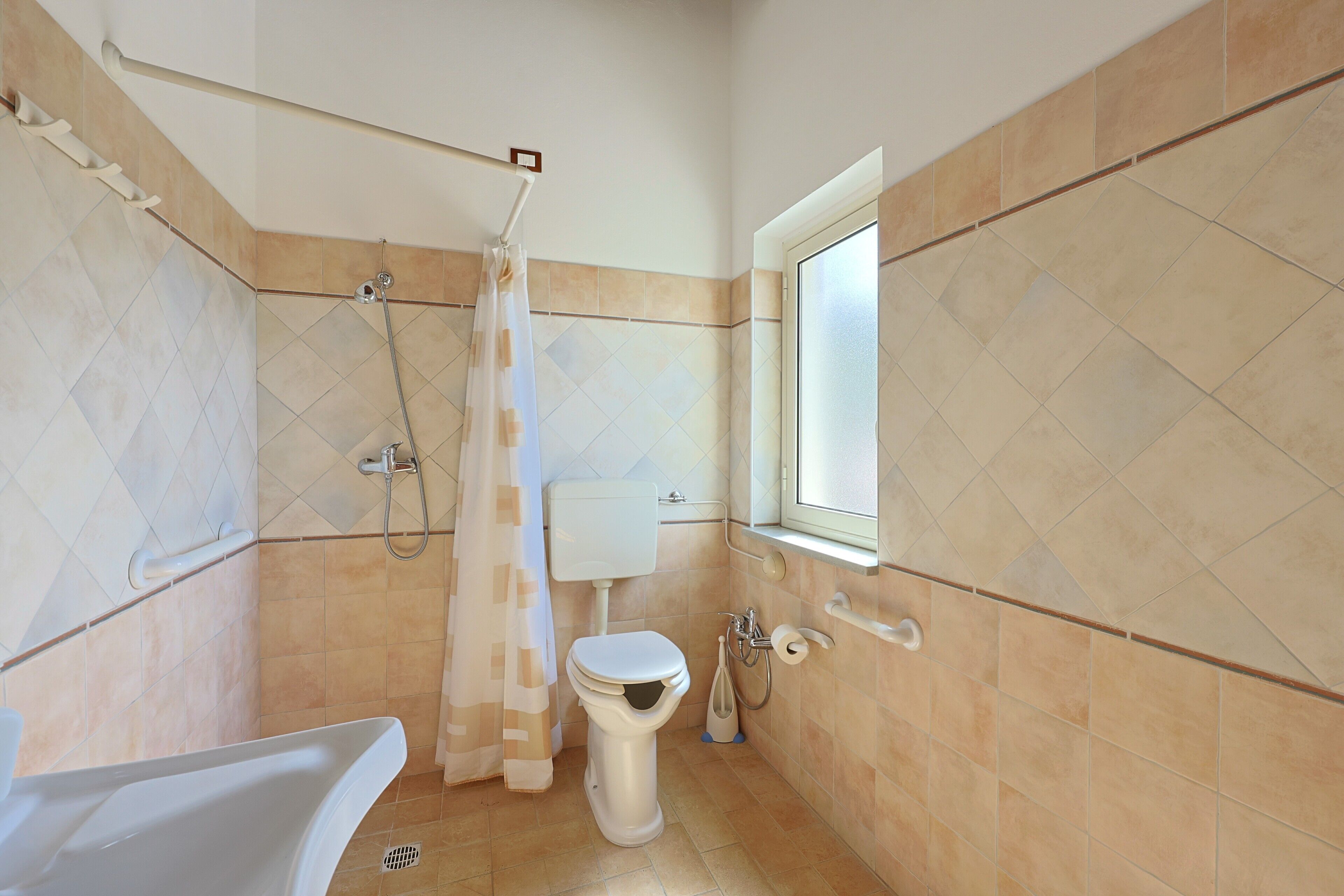 Ein Badezimmer mit Toilette, Dusche und Badewanne.