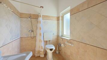 Ein Badezimmer mit Toilette, Dusche und Badewanne.