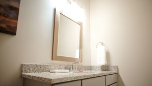 A bathroom with a granite countertop, a sink, a mirror, and a towel rack. - Stay At The Mill In Oxford (Oxford)