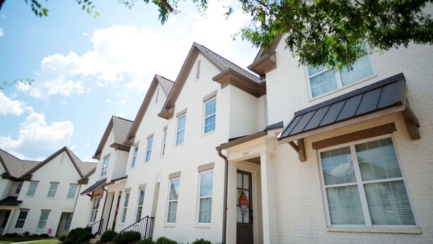 A row of modern townhouses with a uniform architectural style, featuring a central entrance with a door and windows on each side. - Stay At The Mill In Oxford (Oxford)