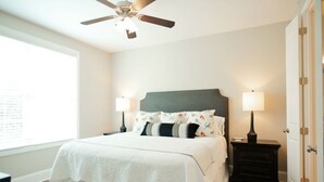 A bedroom with a bed, two bedside tables with lamps, a ceiling fan, and a window. - Stay At The Mill In Oxford (Oxford)