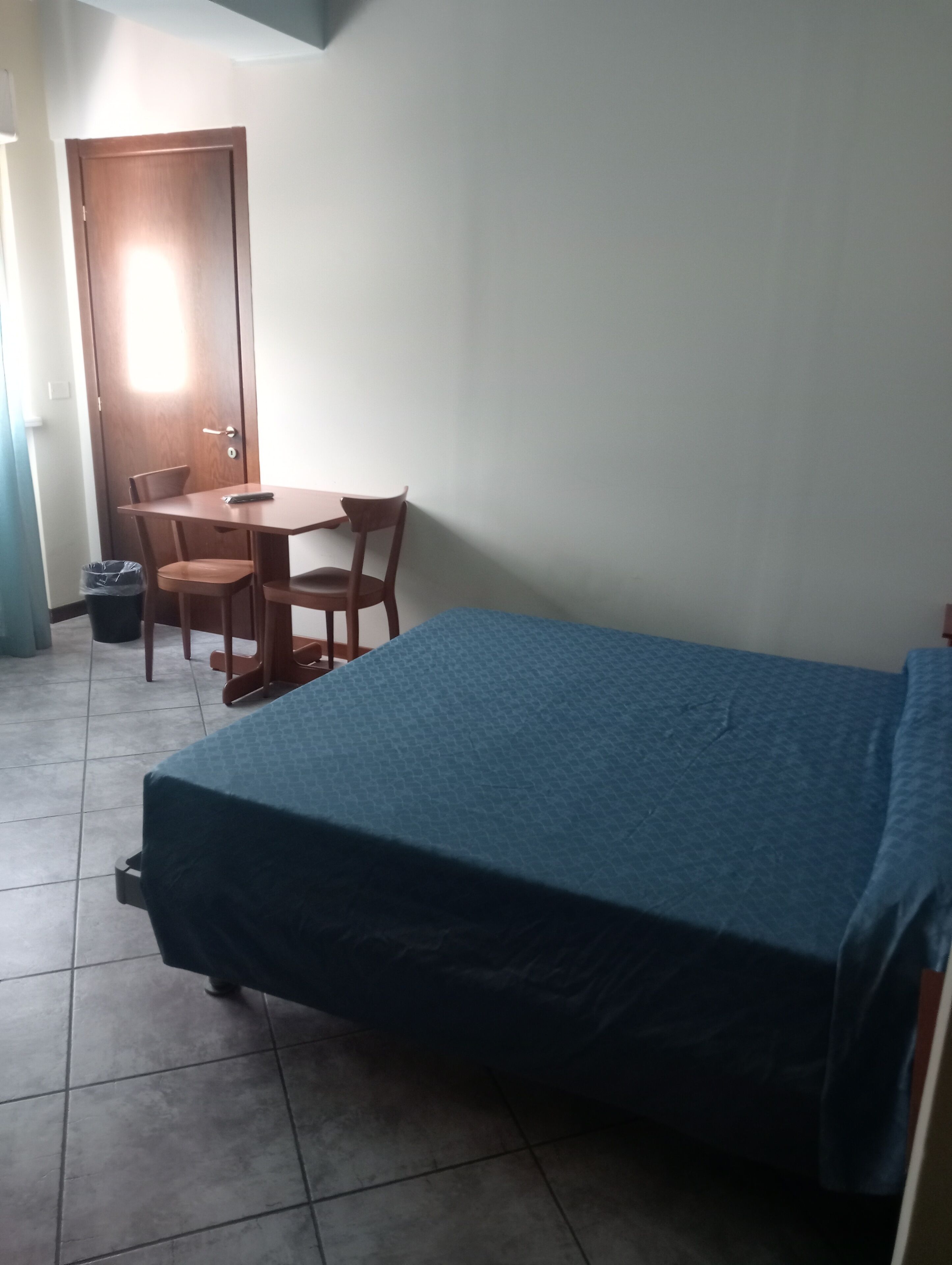 Una habitación con una cama, un escritorio y una silla.