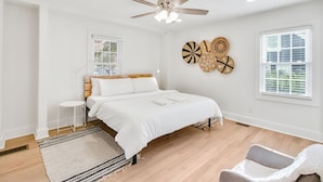 A bedroom with a bed, a ceiling fan, a window, and a wall decoration. - Charming 3BR Retreat in Chamblee (Chamblee)