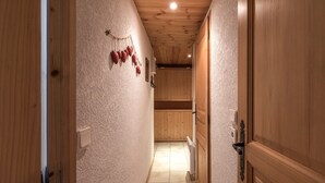 Un pasillo estrecho con paredes y puerta de madera a la derecha.