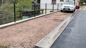 Un barrio residencial con una casa blanca, un camino de grava y una calle pavimentada.