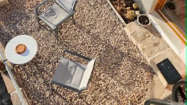 Un patio con una zona de estar, una mesita con un plato y una taza, y un letrero que dice "Constellation".